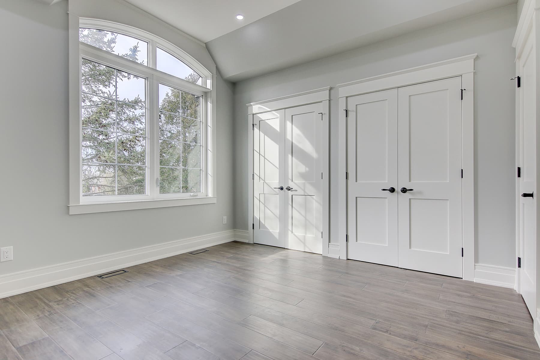 Shaker double doors and arched window casing in a bright room, Uniline project